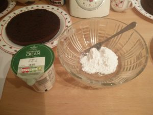 Sugar in a mixing bowl with a carton of cream next to it