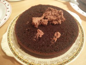 The whipping cream dolloped onto the second cake layer