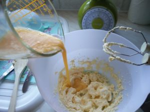 The eggs being added to the butter and sugar mixture