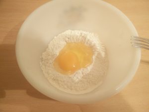 An egg sitting on top of the flour