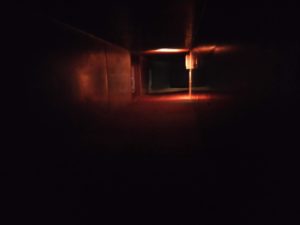 A photo looking inside the dimly-lit ducting