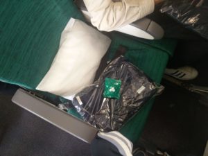 A blanket and headphones provided on my plane seat